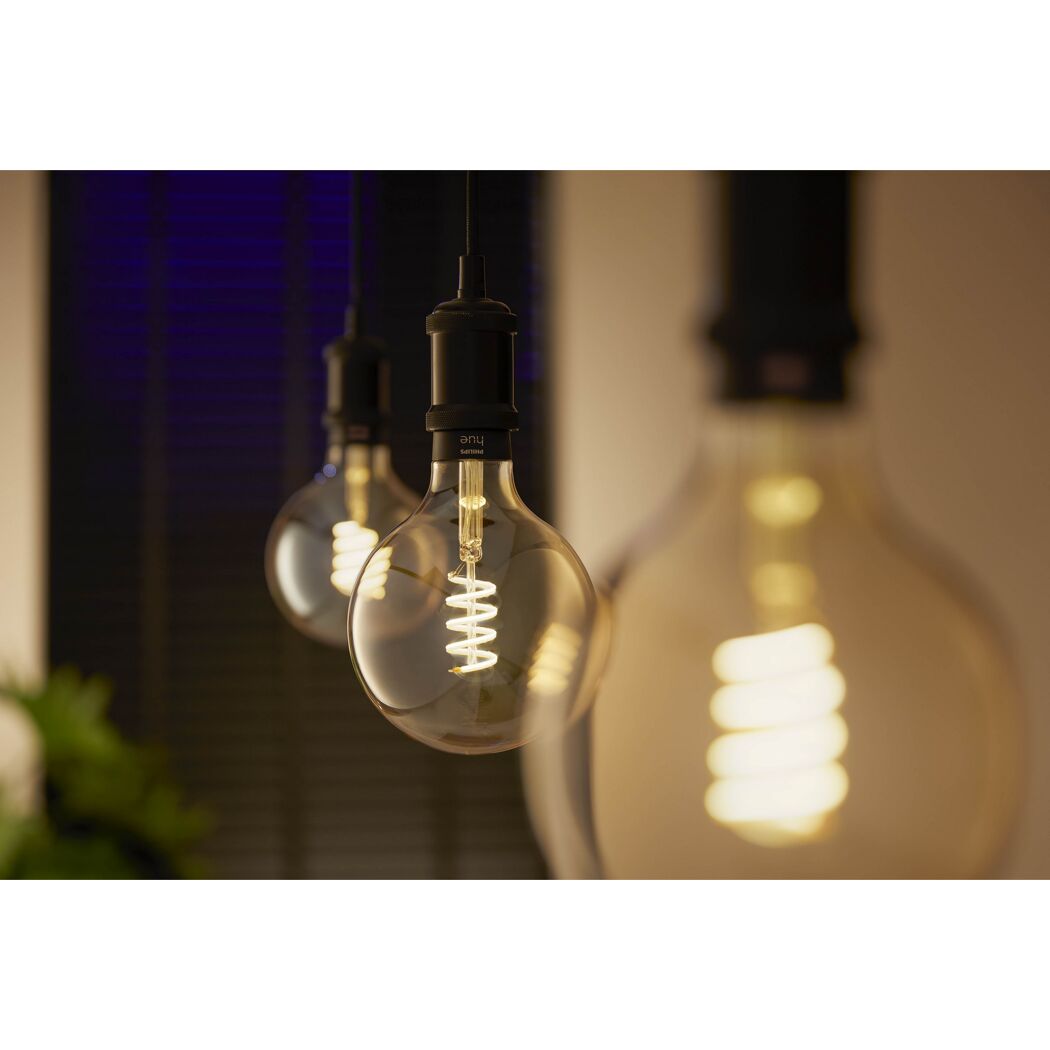 Nahaufnahme Philips Hue Globe LED-Leuchtmittel gold warmweiß.