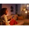 Person steuert LED-Leuchtmittel mit Smartphone auf Sofa.