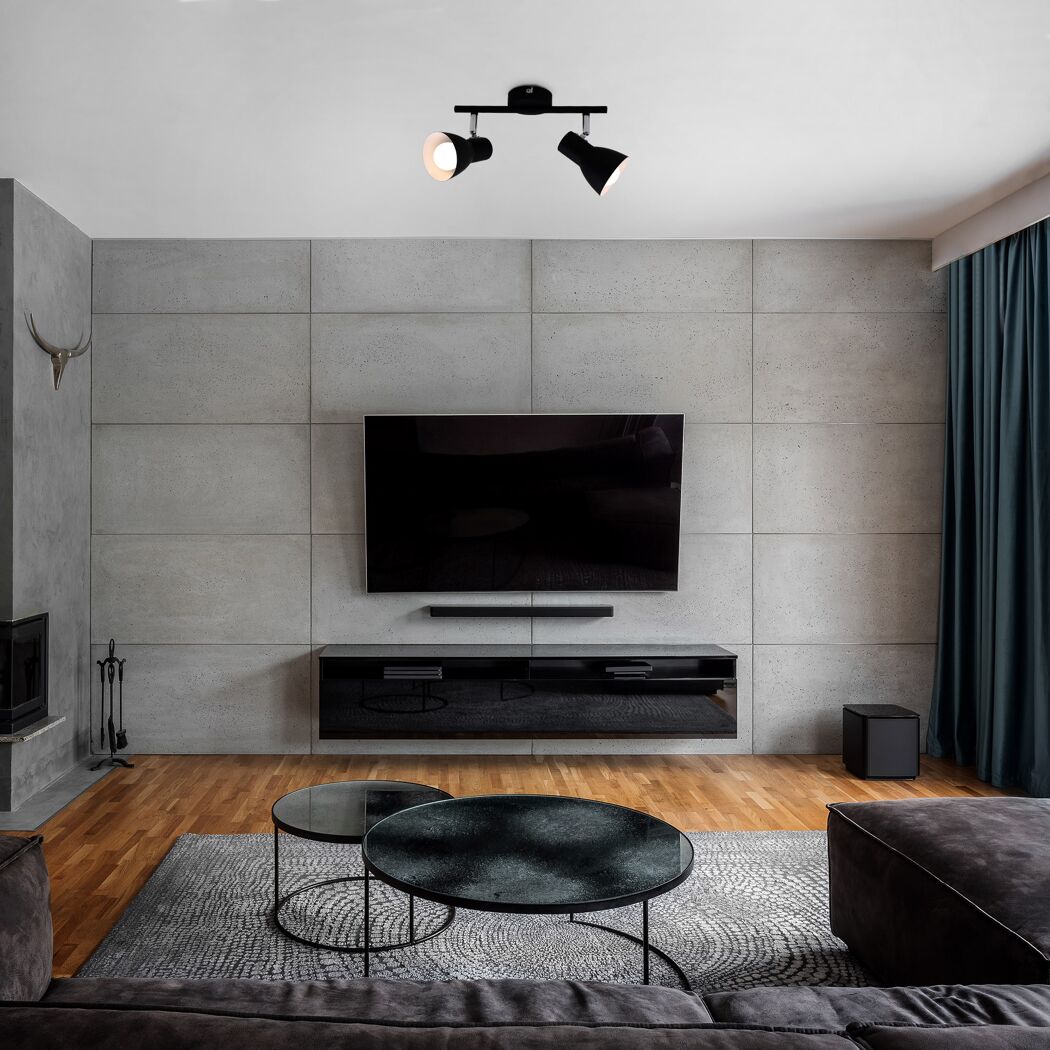 Modernes Wohnzimmer mit Betonwand und großem Fernseher