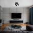 Modernes Wohnzimmer mit Betonwand und schwarzer Deckenleuchte