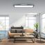 Wohnzimmer mit beiger Couch, braunem Teppich und Lampe