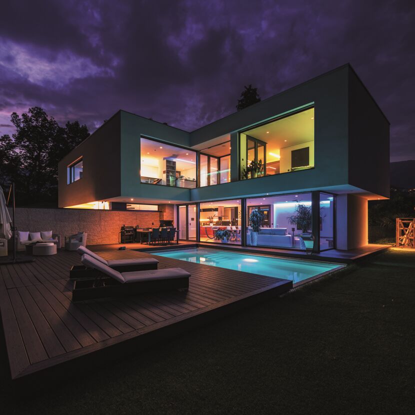 Modernes Haus mit Pool bei Nacht beleuchtet