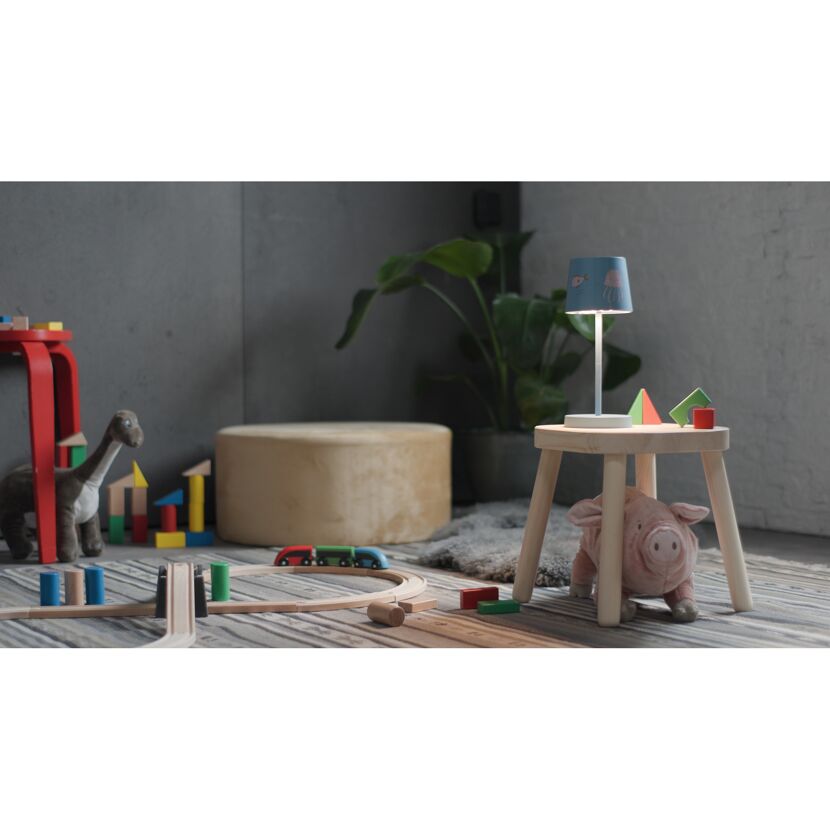 Kinderzimmer mit Spielzeug und leuchtender Tischlampe