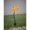 Gelbe, metallene Solar-Blume im Rasen