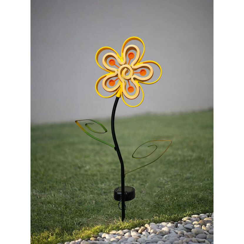 Gelbe, metallene Solar-Blume im Rasen
