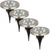 Vier beleuchtete silberne LED-Solar-Bodenstrahler.