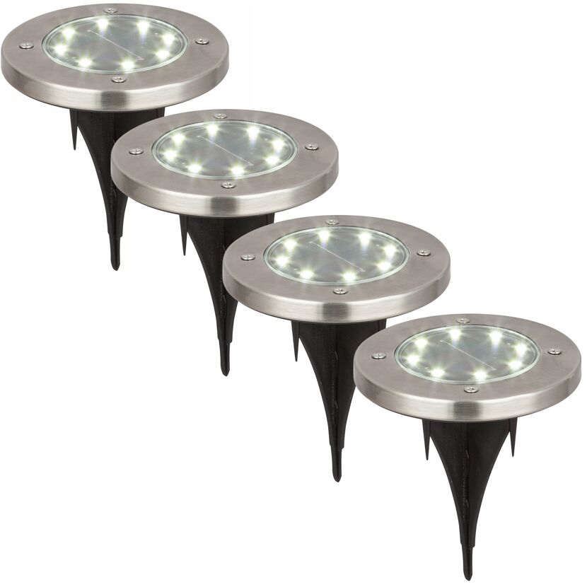Vier beleuchtete silberne LED-Solar-Bodenstrahler.