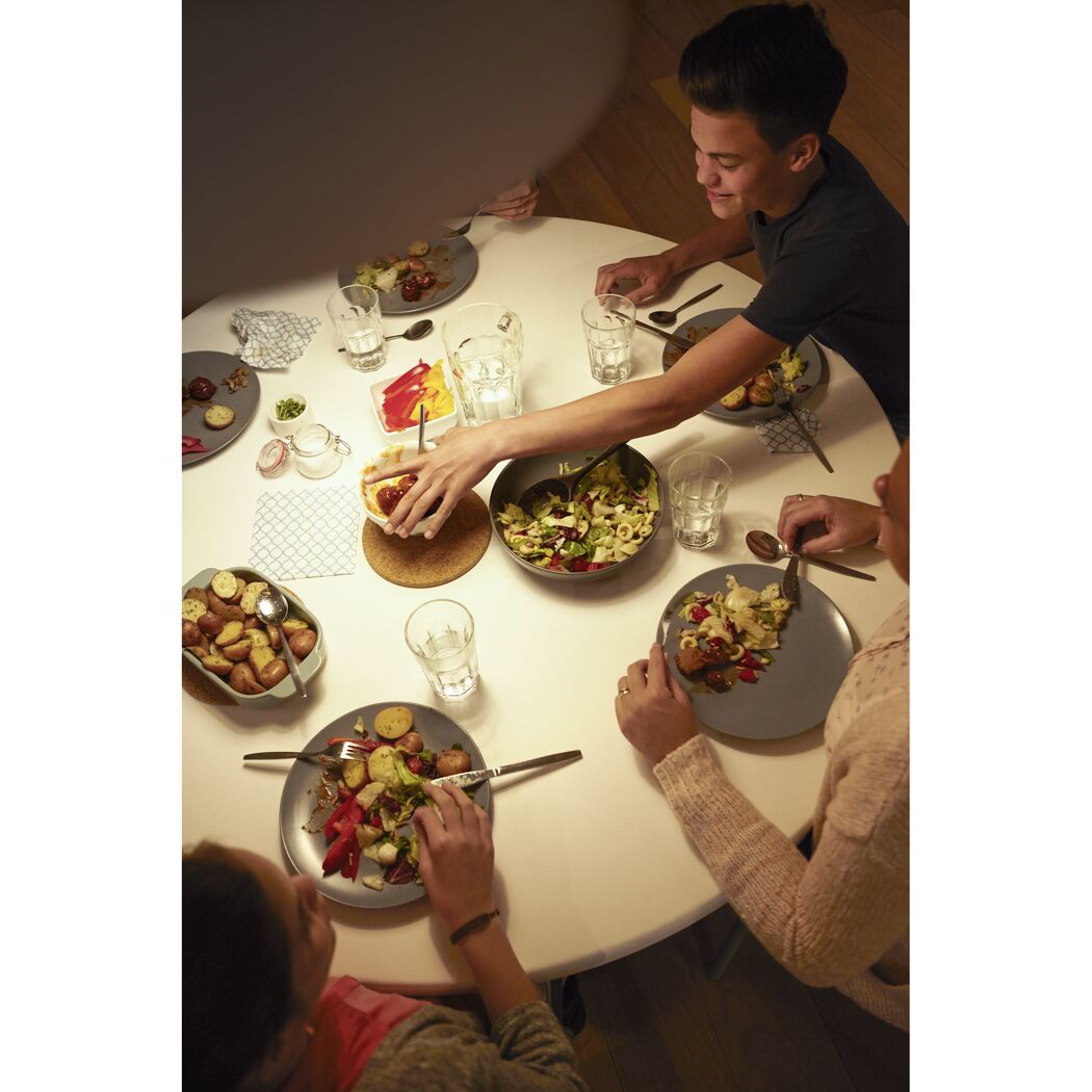 Familie beim Abendessen an einem runden Tisch.