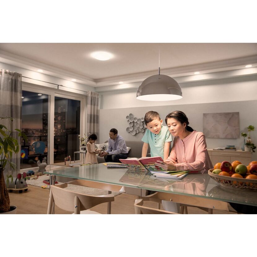Familie liest abends am Esstisch in einem modern eingerichteten Wohnzimmer.