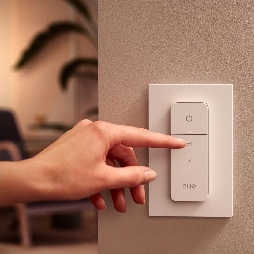 Person drückt die Lichttaste am Philips Hue Dimmer Switch.