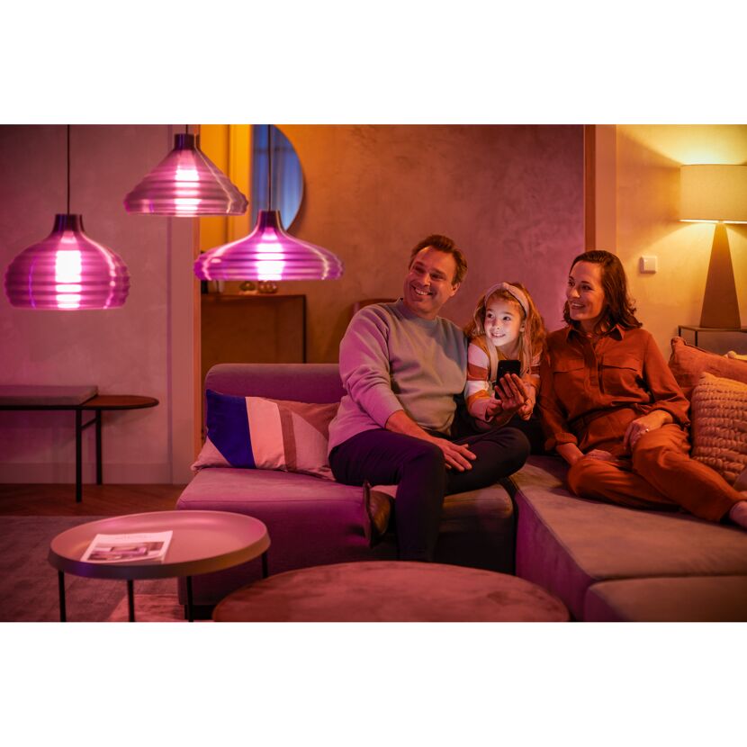 Familie steuert 'Hue' Lichtfarben im Wohnzimmer per Smartphone.