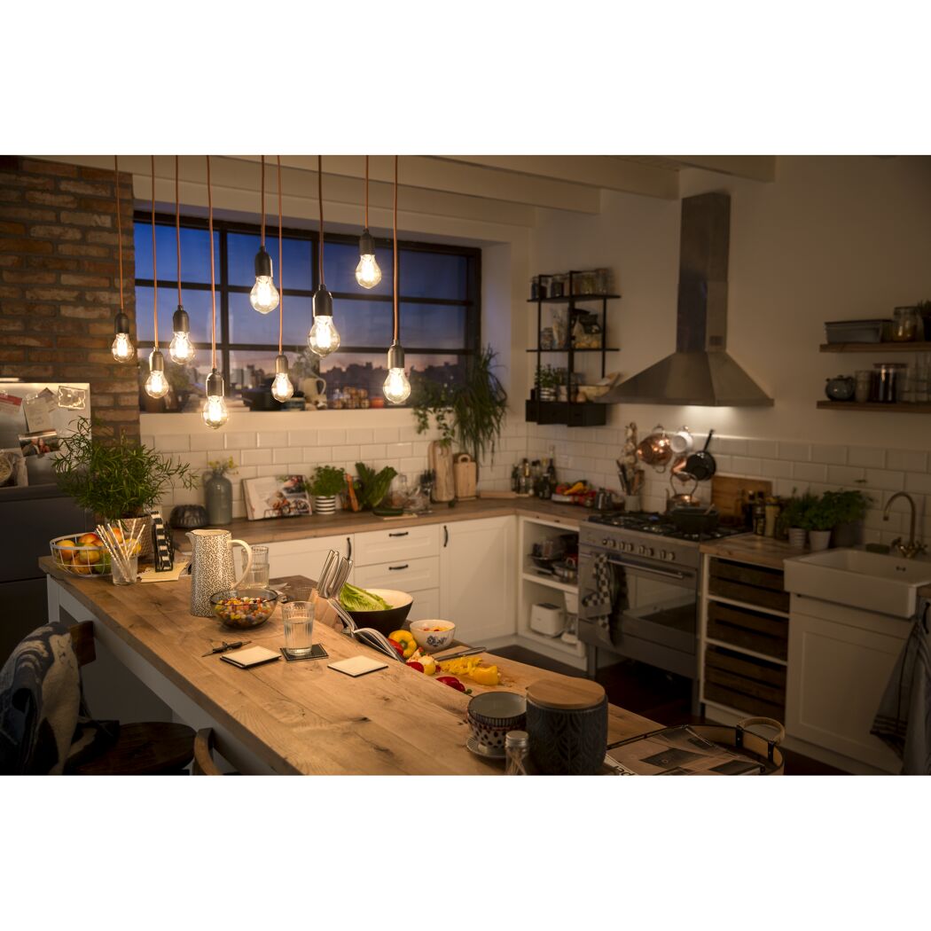 Hängende LED-Kerzenlampen leuchten eine rustikale Küche warmweiß aus.