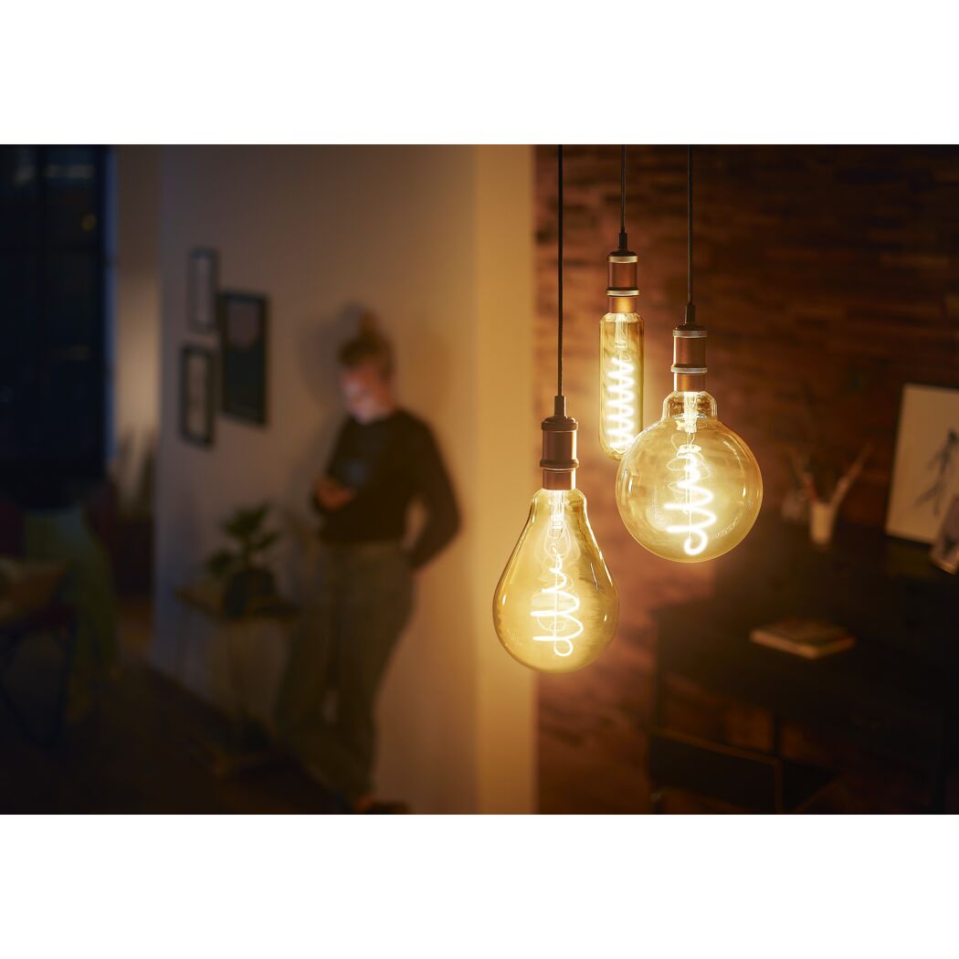 Drei goldene LED-Leuchtmittel beleuchten einen warmen Raum