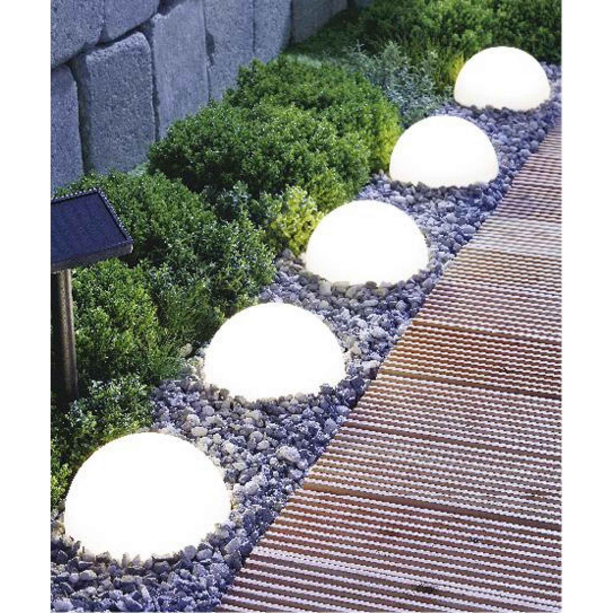 Leuchtende Kugelleuchten auf einem Gartenweg