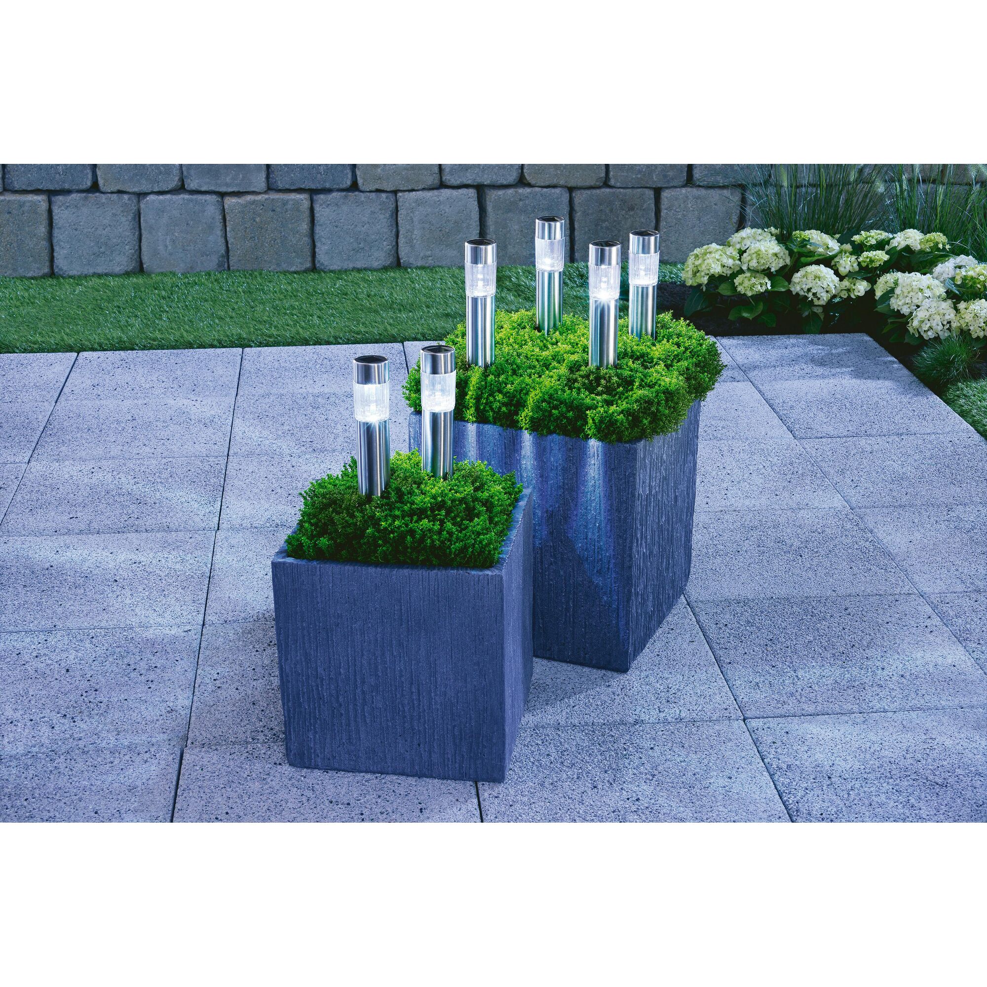 Zwei graue Pflanzkübel mit Solarleuchten