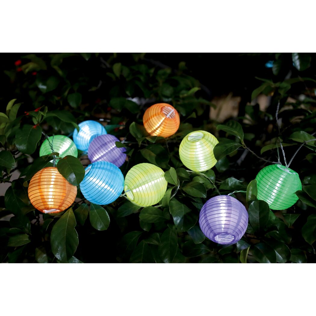 Bunte Lampions hängen an einem Baum.