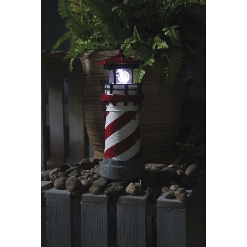 Leuchtender Solar-Leuchtturm auf grauen Holzlatten