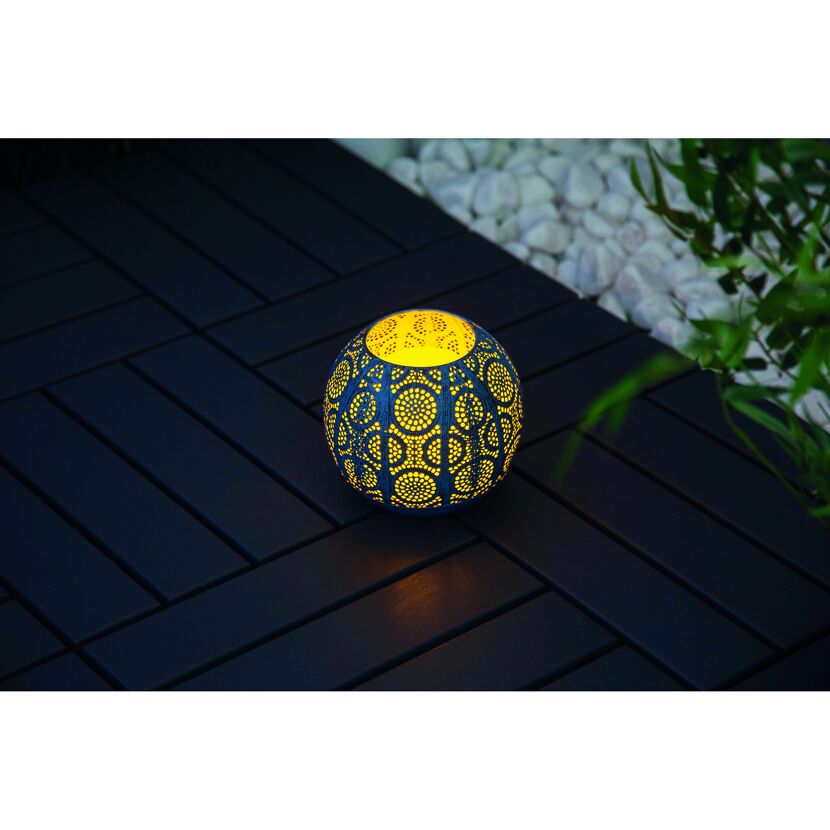 Runde Solar-Laterne mit Lochmuster leuchtet gelb.
