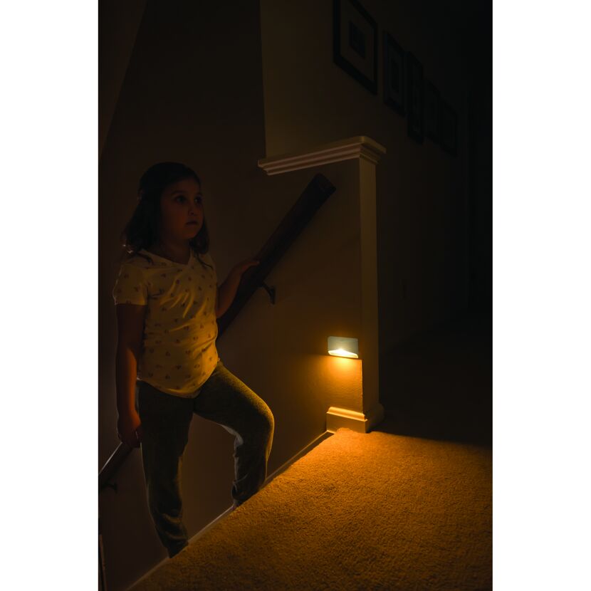 Kind geht nachts beleuchtete Treppe hinauf