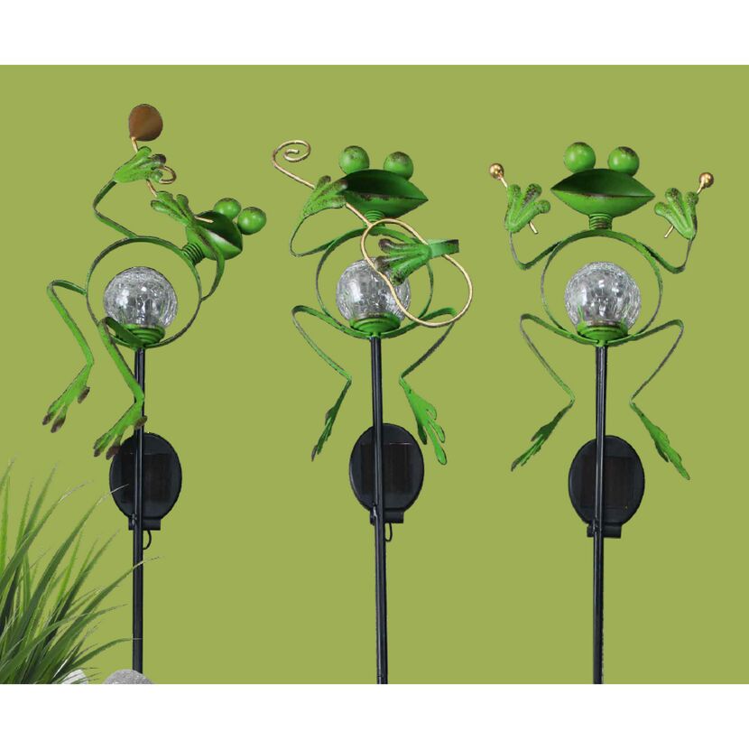 Drei grüne Frosch-Figuren mit Solarlampen als Musikinstrumenten.
