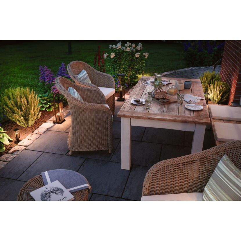 Gemütliche Sitzecke im Garten mit beleuchtetem Tisch