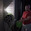 Person füllt Gießkanne mit Gartenschlauch