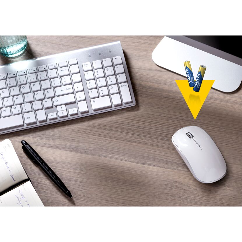 Tastatur, Maus, Notizbuch, Stift und Batterien auf einem Tisch