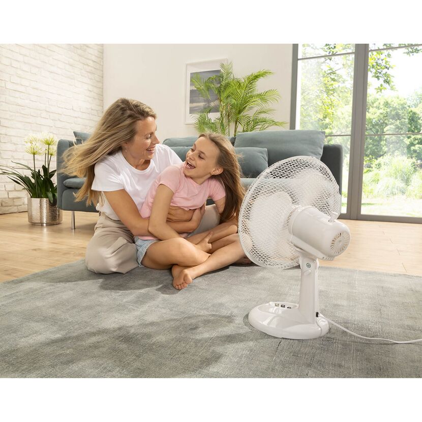 Mutter und Kind sitzen vor einem Ventilator
