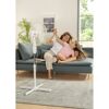 Person und Kind sitzen auf Sofa vor Standventilator