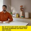 Person tippt an weißer Tastatur. Im Hintergrund ein Luftreiniger.
