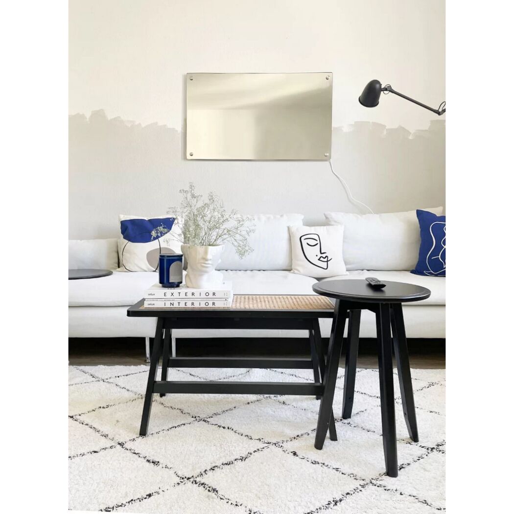 Weißes Wohnzimmer mit Spiegelheizung an der Wand