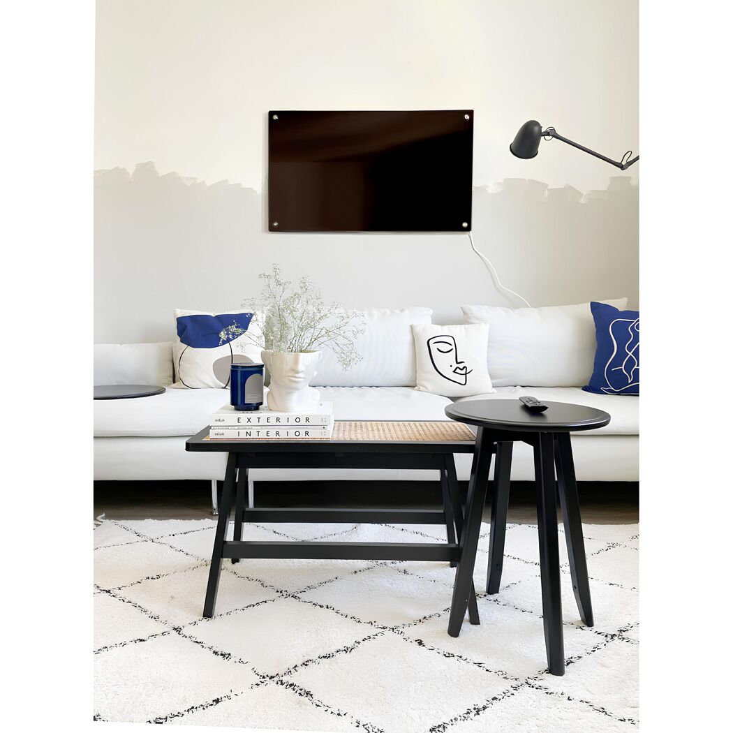 Wohnzimmer mit weißer Couch, schwarzem Beistelltisch und Infrarotheizung