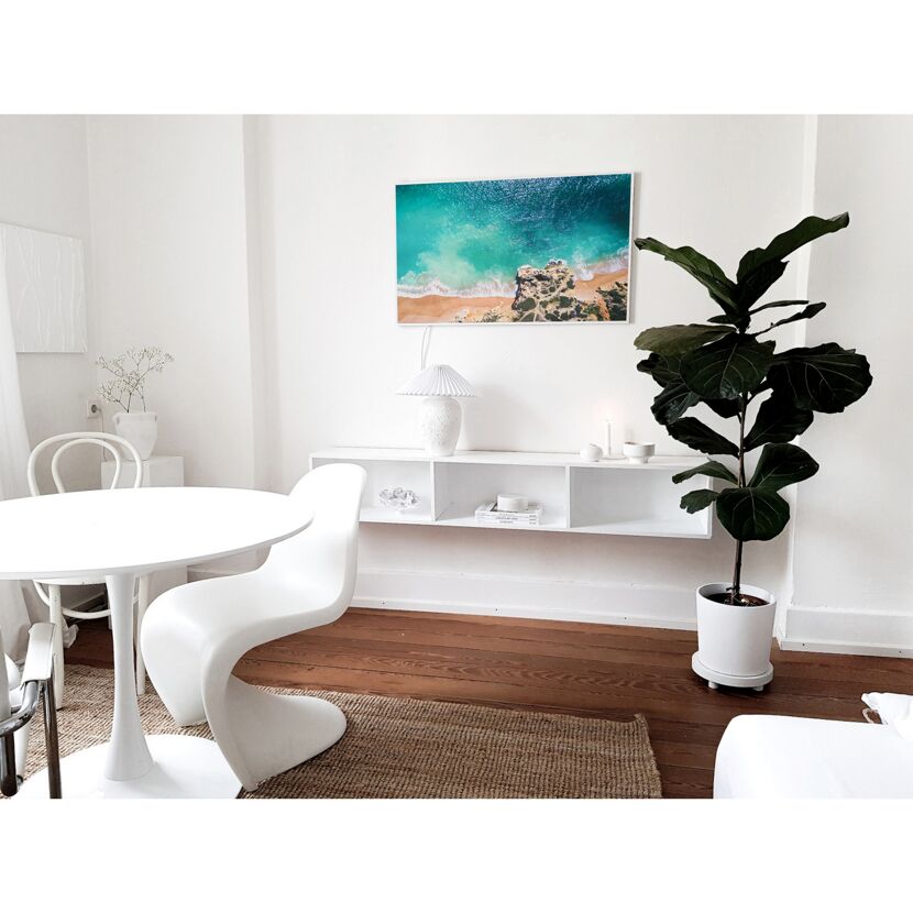 Esszimmer mit Strandbild und großer Pflanze