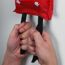 Person hält eine Feuerlöschdecke an den Schlaufen