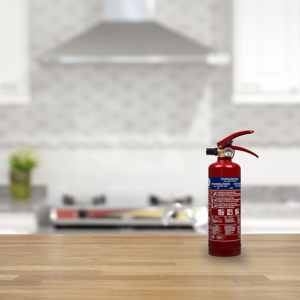 Ein roter Feuerlöscher steht auf einer Holzoberfläche.