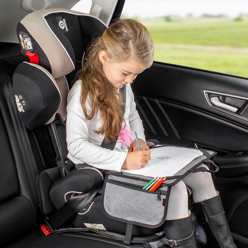 Kind malt auf einer Malunterlage im Auto