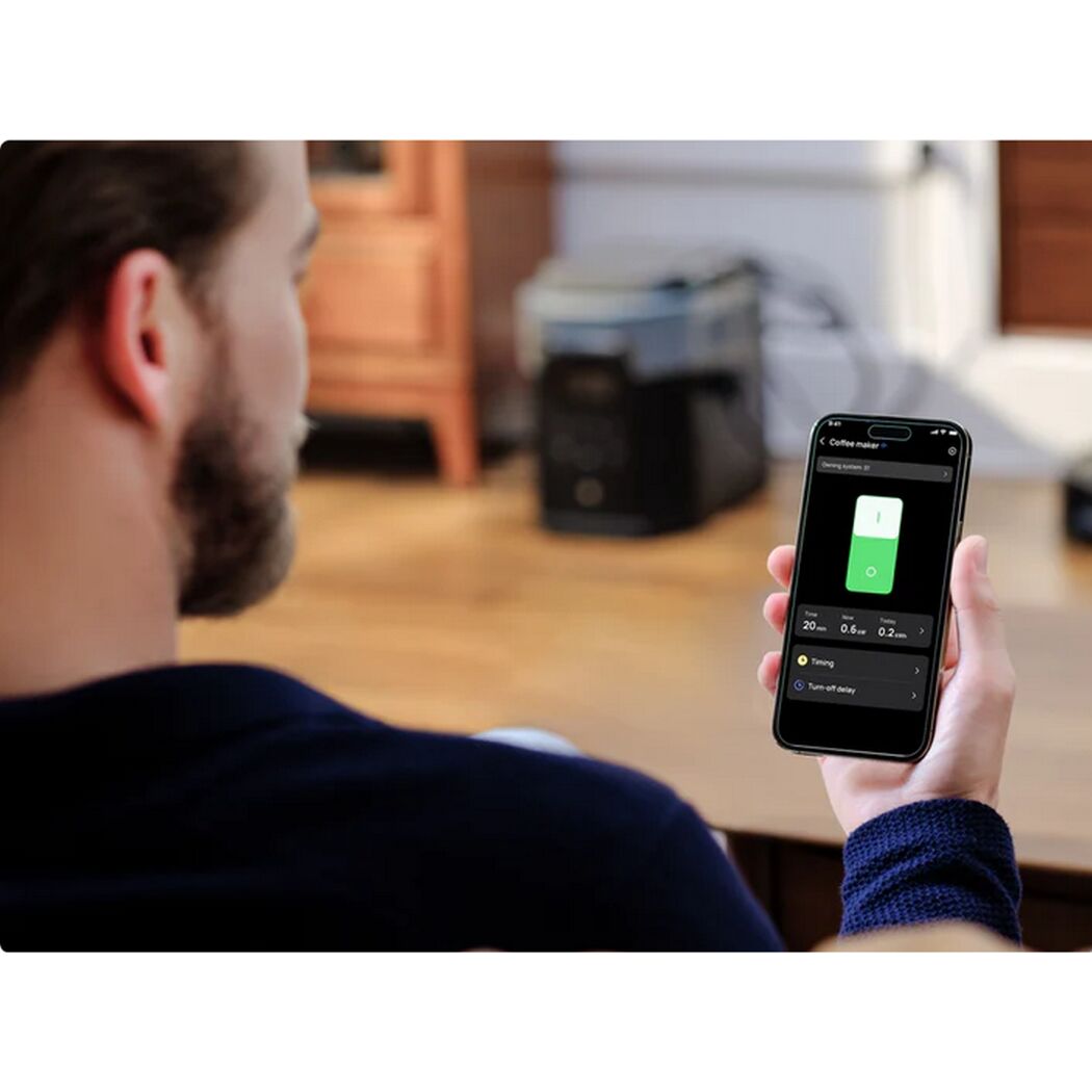 Person steuert Kaffeemaschine per App