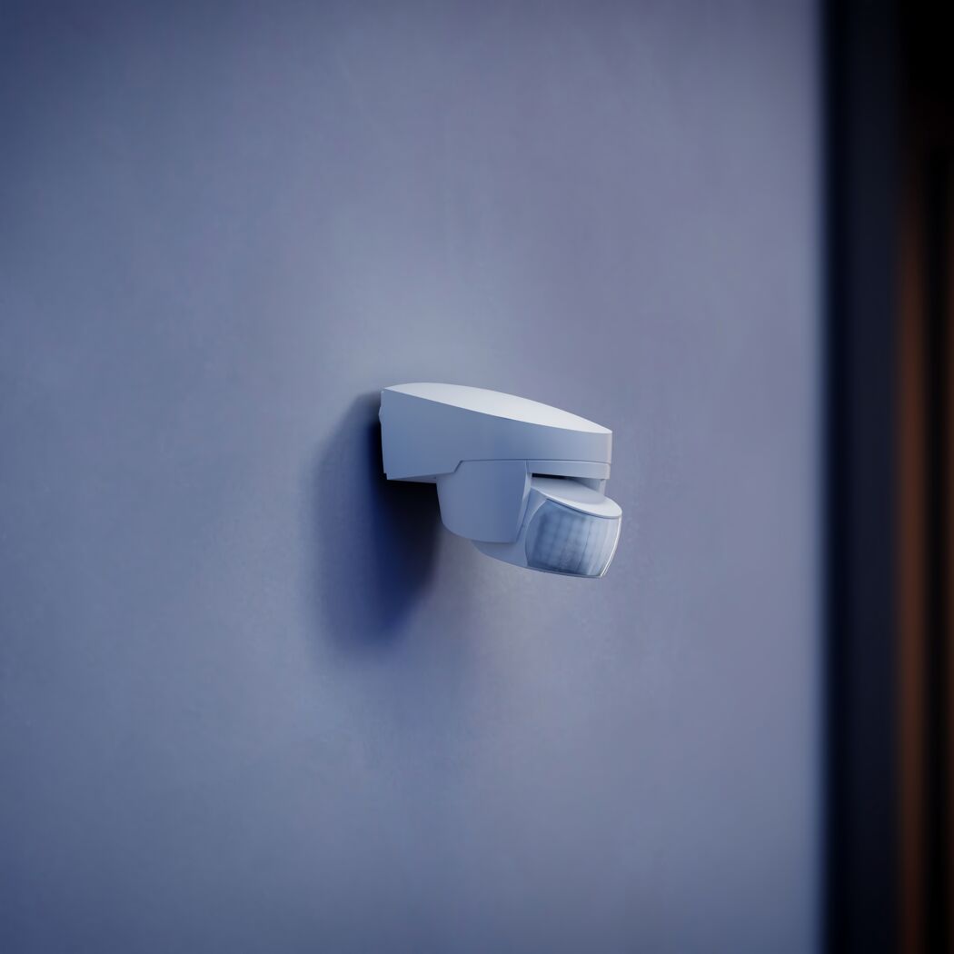Weißer Bewegungsmelder an blauer Wand