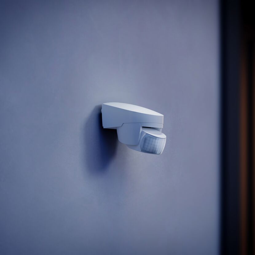 Weißer Bewegungsmelder an blauer Wand