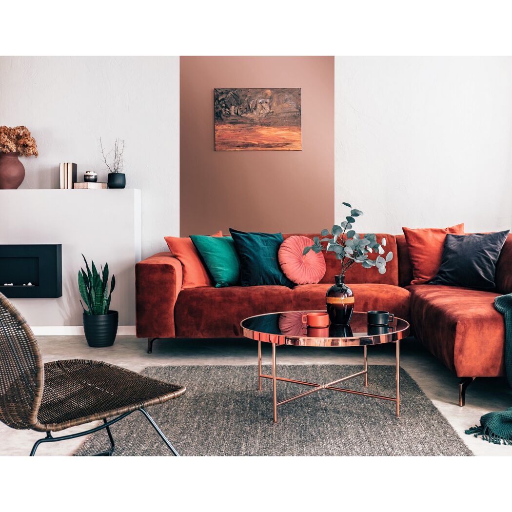 Gemütliches Wohnzimmer mit rotem Sofa, Pflanzen und Deko.