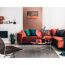 Gemütliches Wohnzimmer mit rotem Sofa, Pflanzen und Deko.