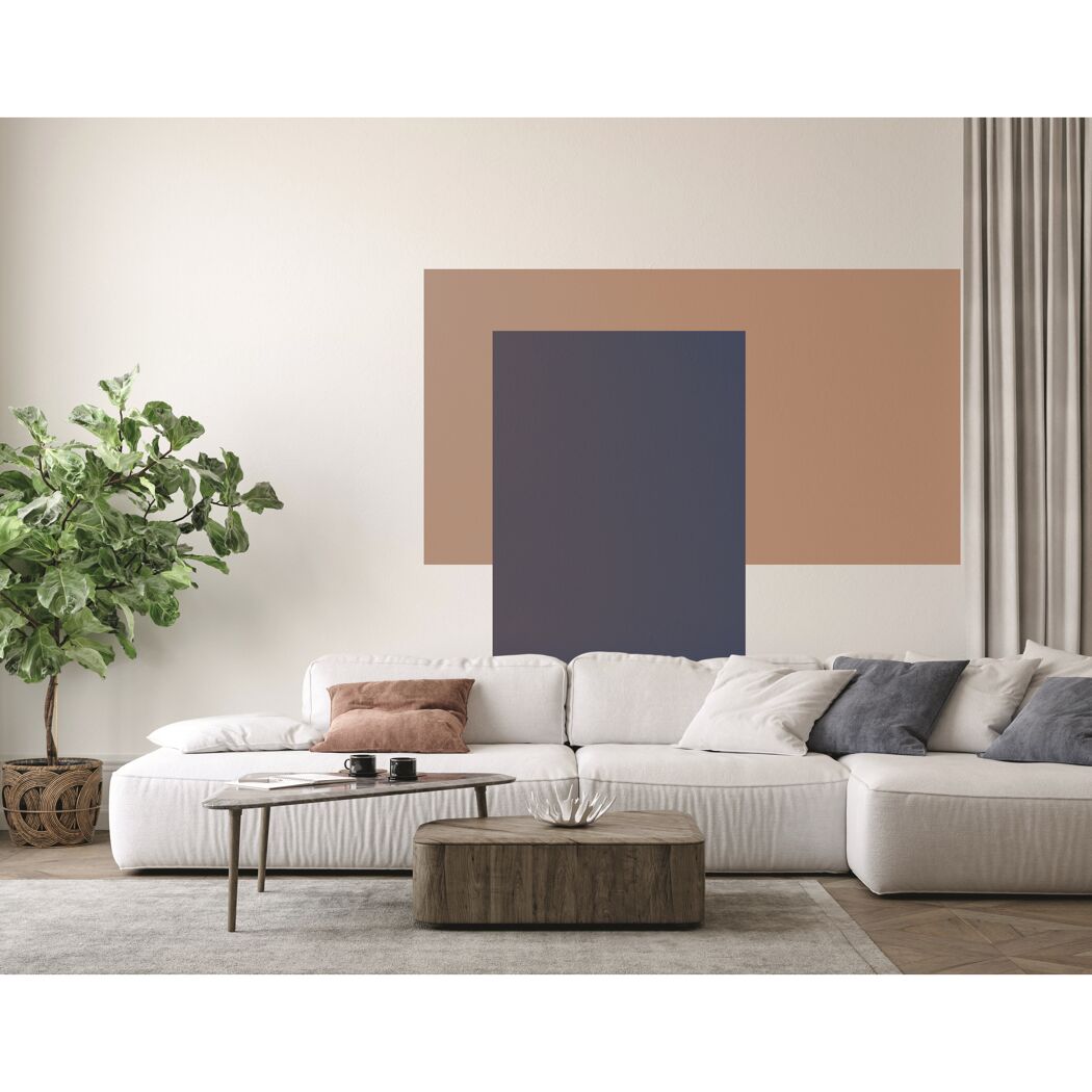Wohnzimmer mit weißem Sofa, braunem Couchtisch, Teppich und Pflanze