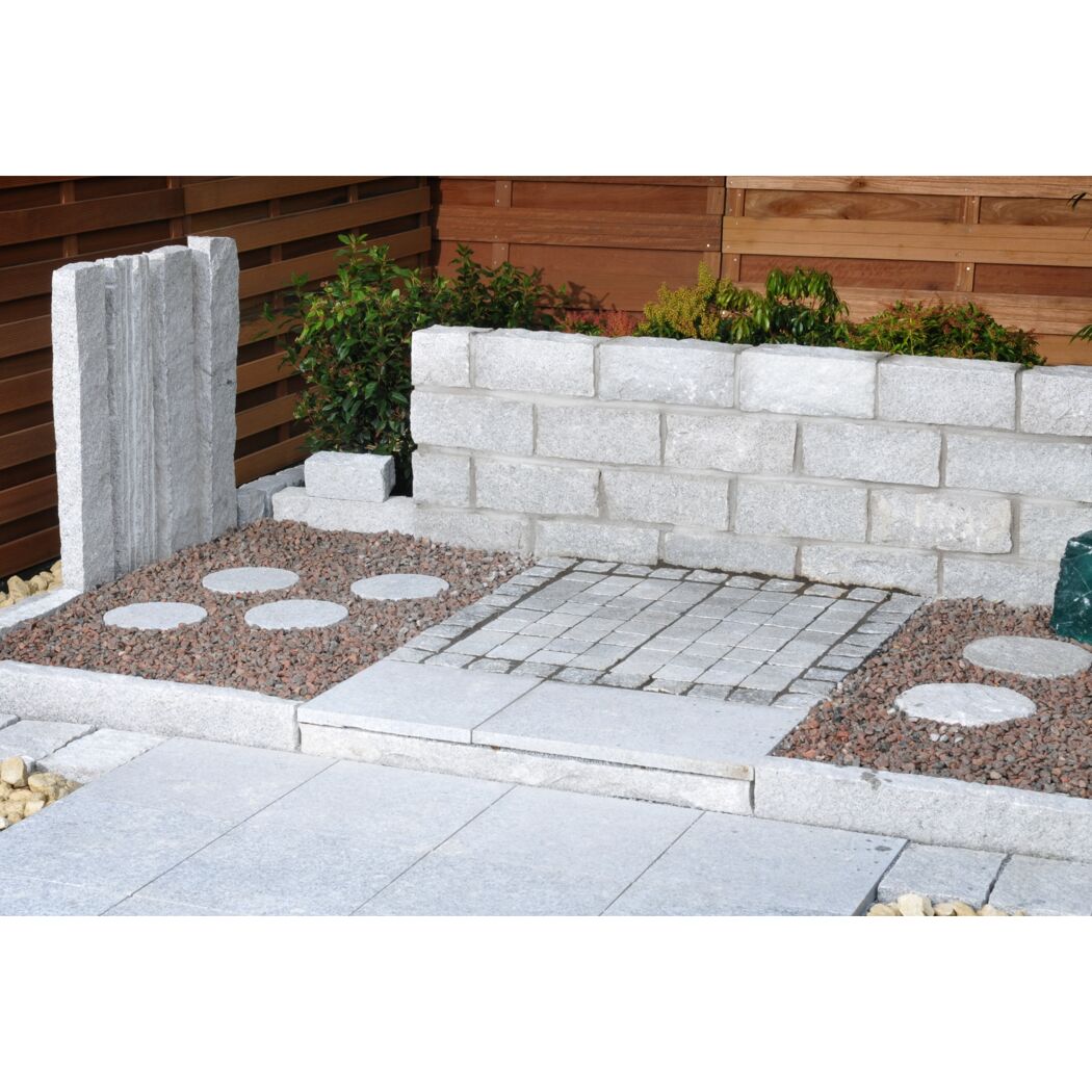 Gestaltete Gartenecke mit Granitplatten und -mauersteinen