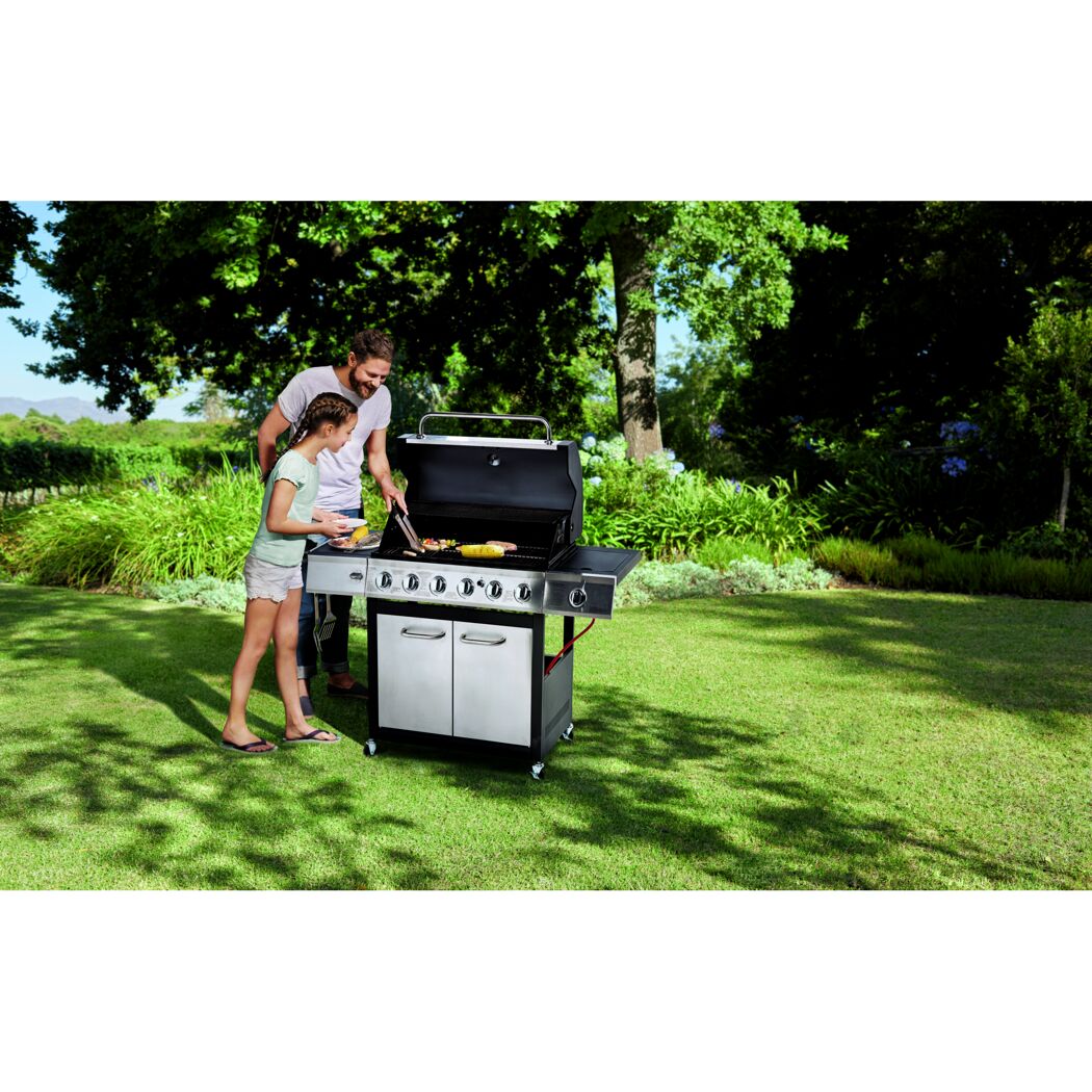 Zwei Personen grillen im Garten mit Gasgrill