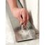Person befestigt eine Metallleiste mit einem Nageldübel.