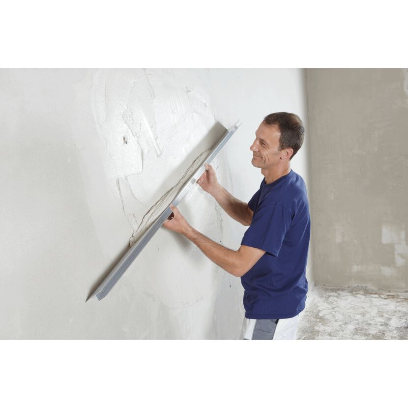 Person verputzt eine Wand mit einer Glättkelle.