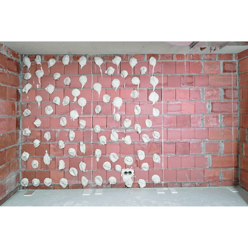 Rote Backsteinwand mit Klecksen Ansetzgip