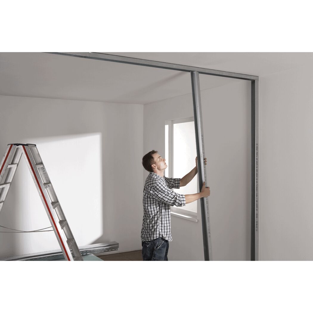 Person montiert eine Metallständerwand.