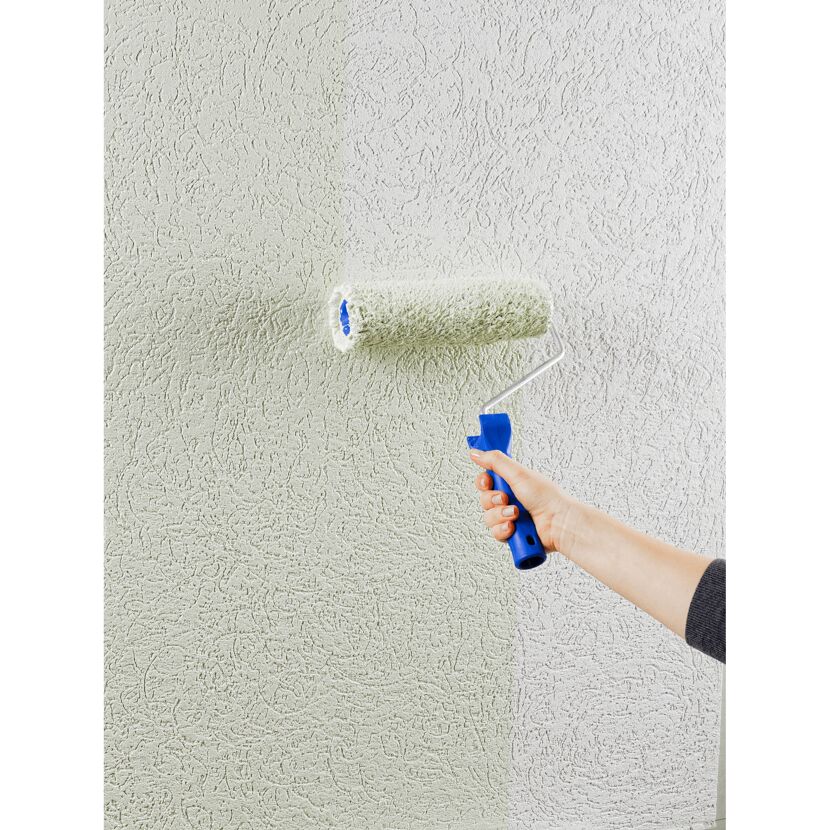 Person streicht eine Wand mit einer Farbrolle.