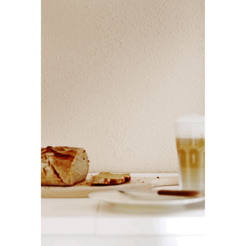 Beige Wand mit Brot und Kaffee auf einem Tisch.